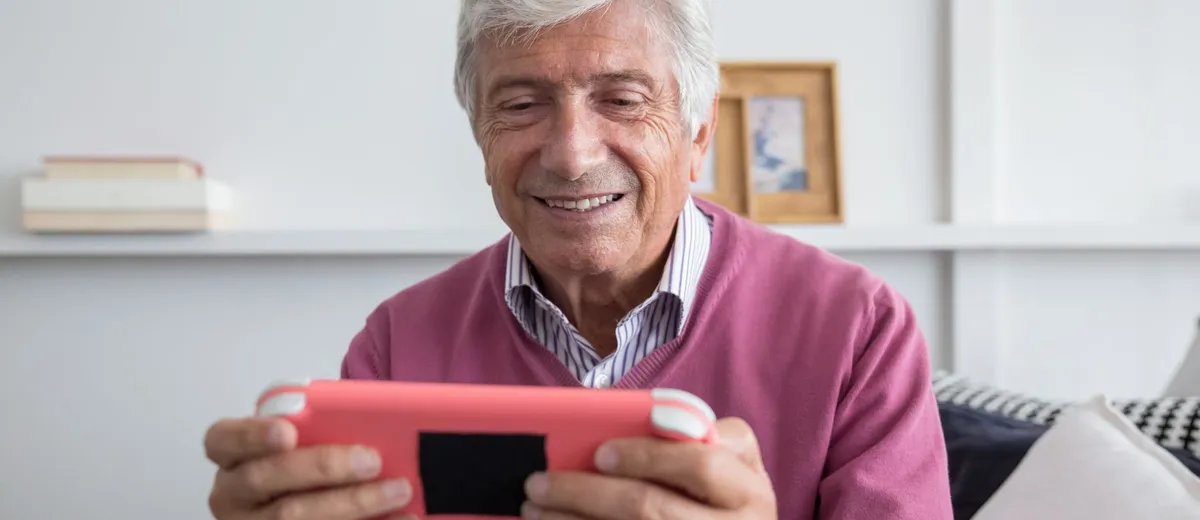 Mesa de testes com tablet em suporte articulado exibindo prancha de comunicação e um acionador vermelho grande